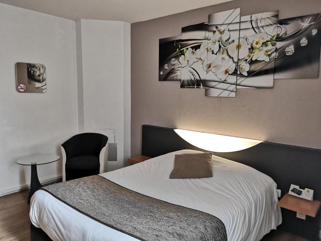 een slaapkamer met een bed en een kroonluchter bij L'Hôtel du Marais Romilly Centre in Romilly-sur-Seine