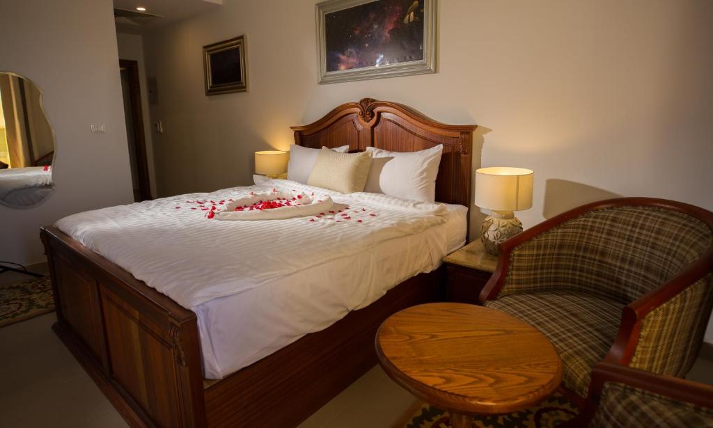 a bedroom with a bed with red rose petals on it at Holy Family Hotel in Jabal aţ Ţayr