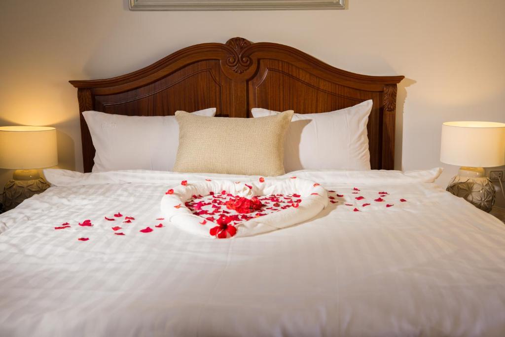 a bed with a bunch of red roses on it at Holy Family Hotel in Jabal aţ Ţayr