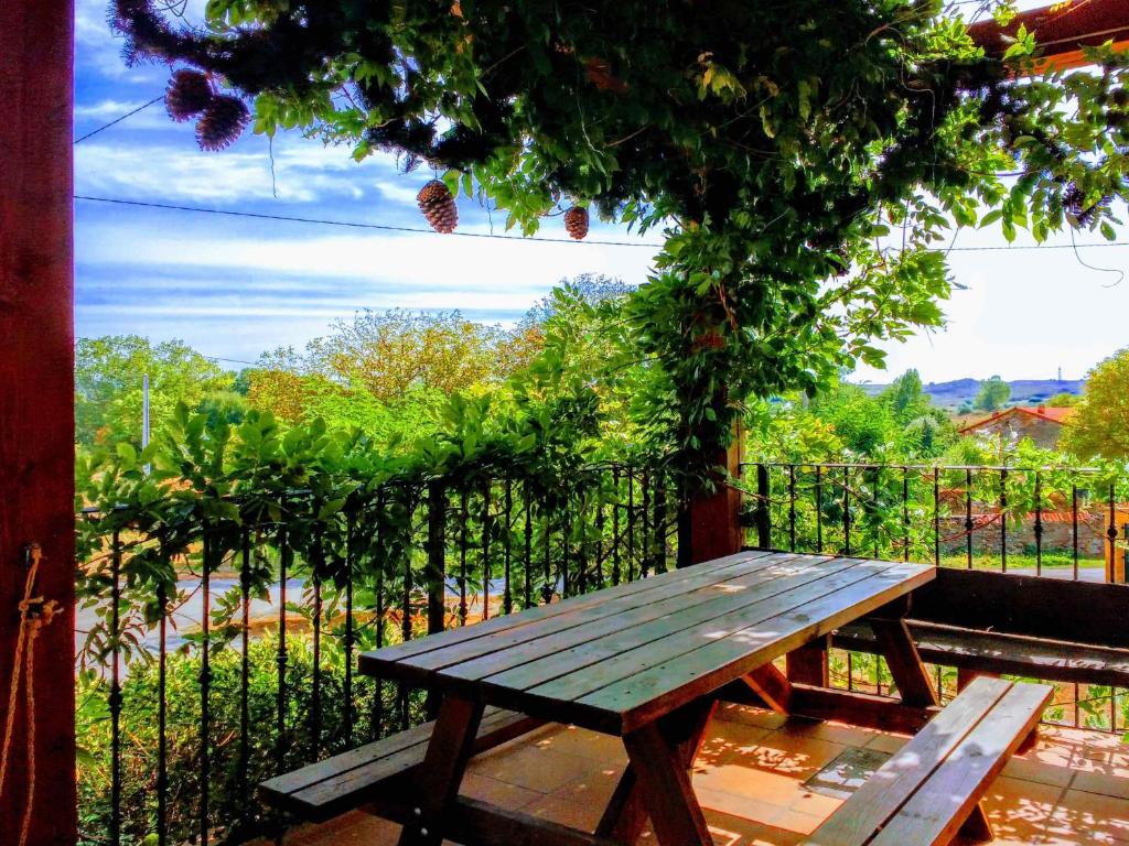 a wooden picnic table sitting in front of a fence at LA CASITA / CASA DE CAMPO in Santa Gadea