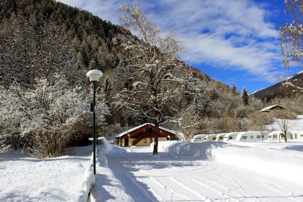 a street light in the snow next to a house at Chalet Presanella in Temù