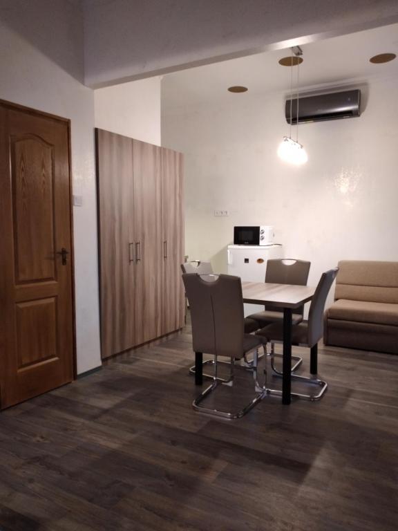 a dining room with a table and chairs and a couch at Bem Downtown Apartment in Debrecen