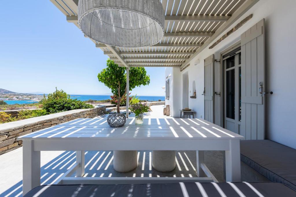 a white table on a porch with a view of the ocean at Villa Spitaki in Aliki