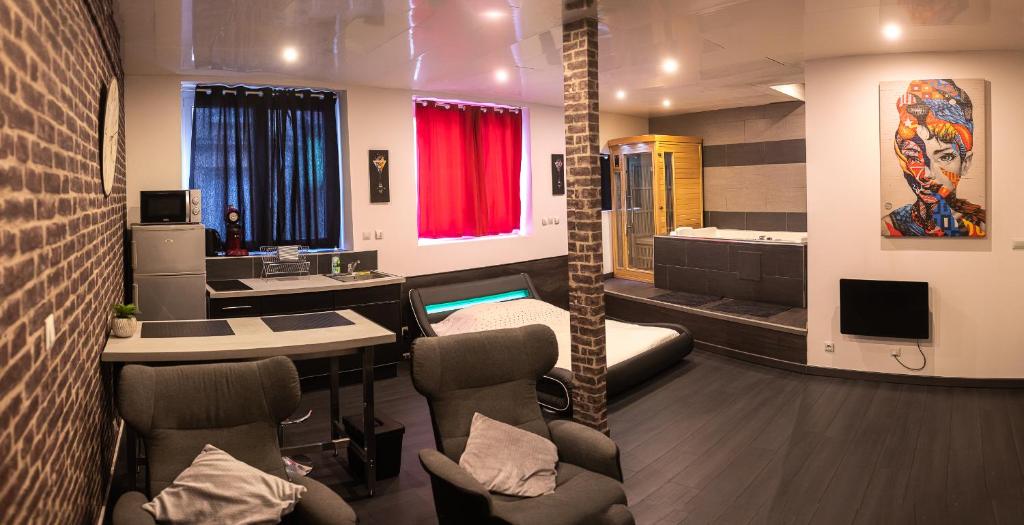 サン・テティエンヌにあるAppartement luxury spaのベッド、テーブル、椅子が備わる客室です。