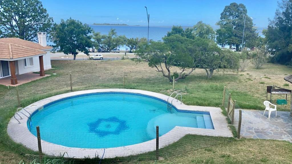 - une grande piscine bleue dans une cour avec une maison dans l'établissement Apartamento con excelente ubicación y vista al Rio, à Colonia del Sacramento