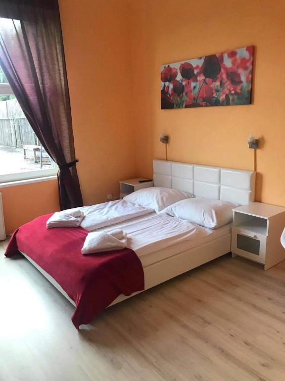 duże łóżko w sypialni z oknem w obiekcie Y Panzió w mieście Balatonlelle