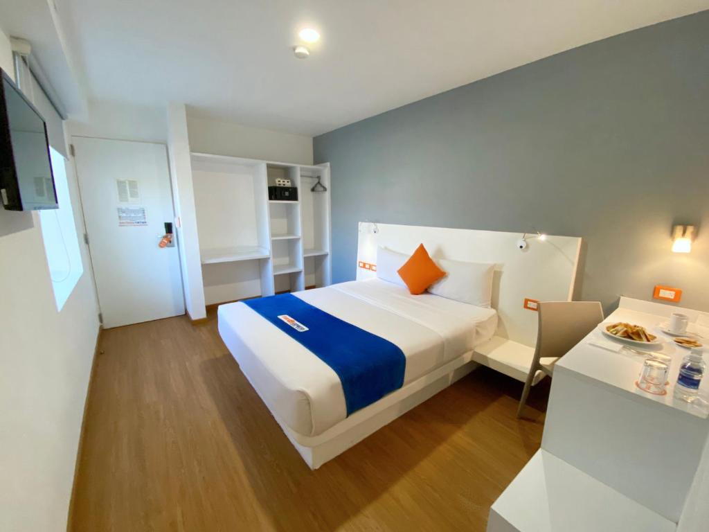 a hotel room with a bed and a table with a table at Hotel Star Express Puebla in Puebla