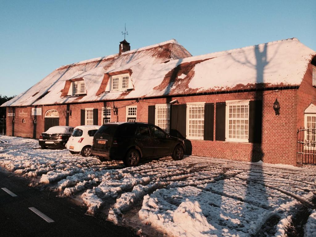 two cars parked in front of a brick building at De Distelhoeve in Helvoirt