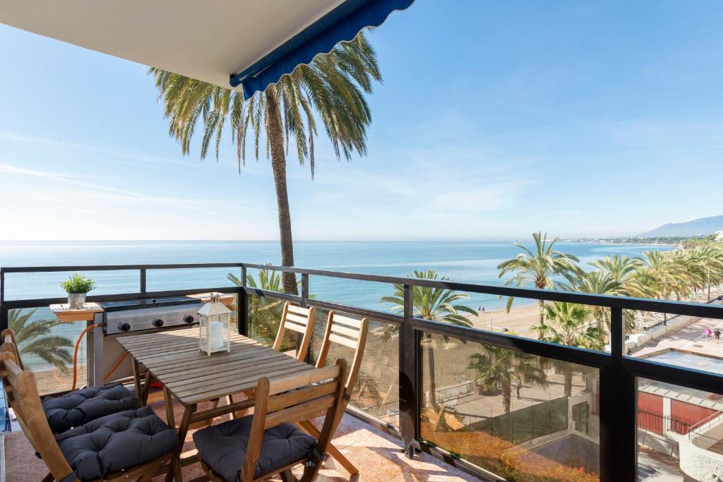 balcón con mesa, sillas y vistas al océano en Skol Sea Views Apartments, en Marbella