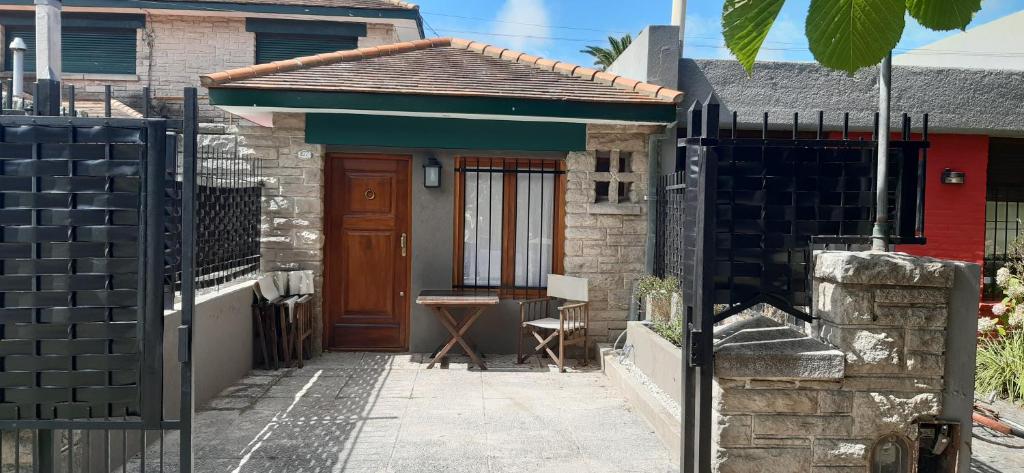 una piccola casa con una porta in legno e una recinzione di La MagnoliaII a Mar del Plata