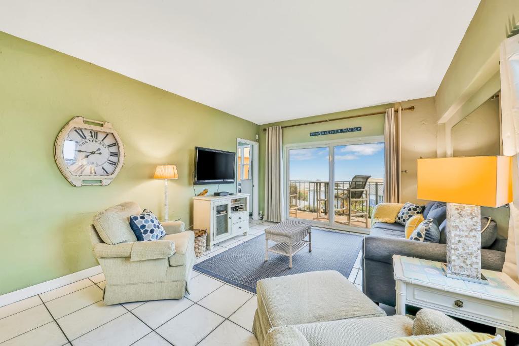 sala de estar con sofá, sillas y TV en Jax Beach OceanFront Getaway, en Jacksonville Beach