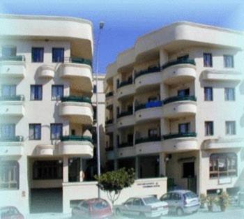 ein großes Apartmenthaus mit davor geparkt in der Unterkunft Apartamentos Mediterraneo in Nerja