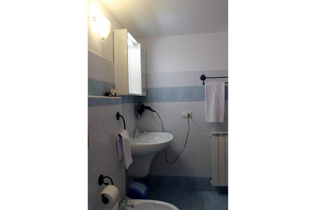 a bathroom with a sink and a toilet and a mirror at Chalet Presanella in Temù