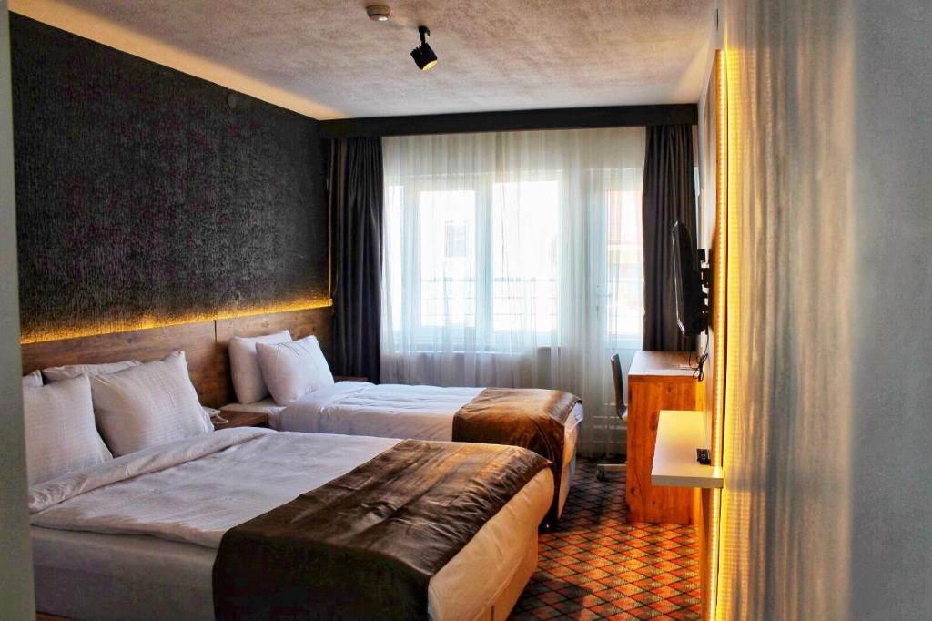 ein Hotelzimmer mit 2 Betten und einem Fenster in der Unterkunft ESKOPPremium OTEL in Bolu
