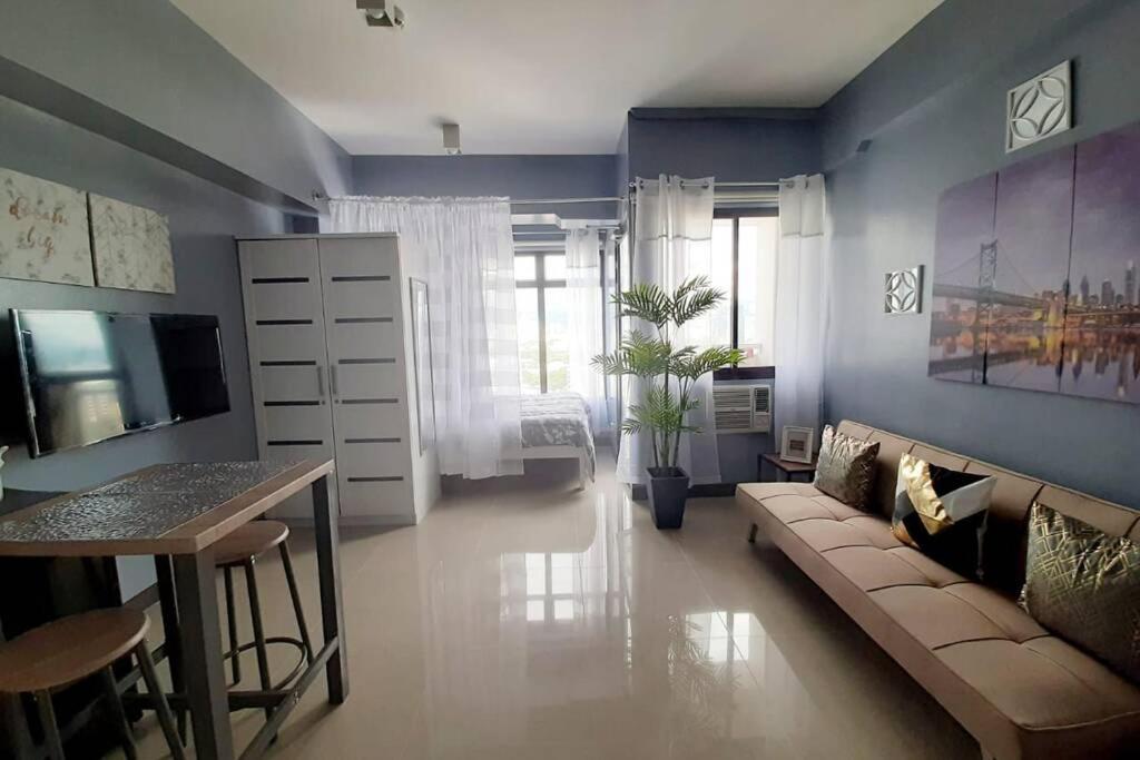 a living room with a couch and a table at Cebu City Apartment - Mabolo Gardens in Cebu City