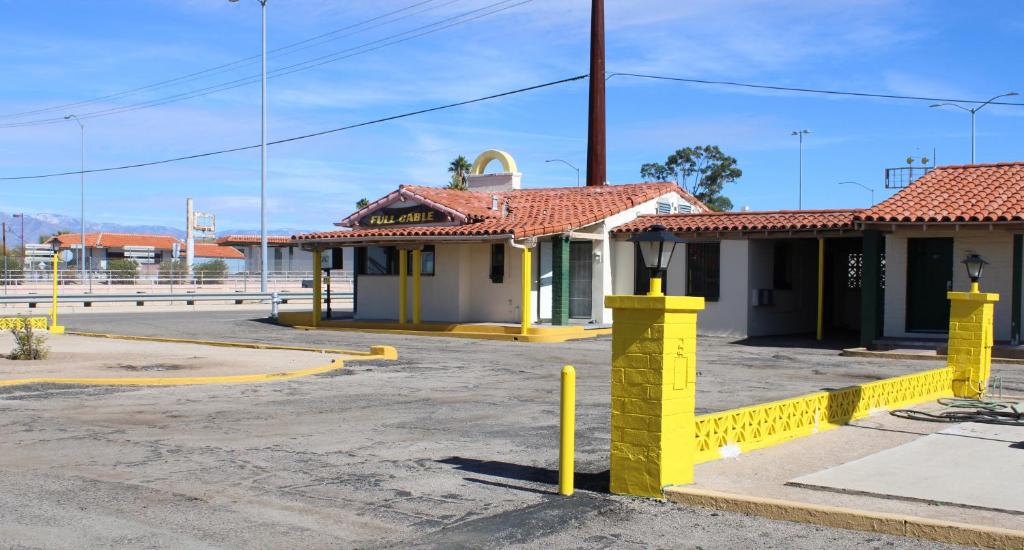 un edificio con postes amarillos en un estacionamiento en Economy Inn en Tucson