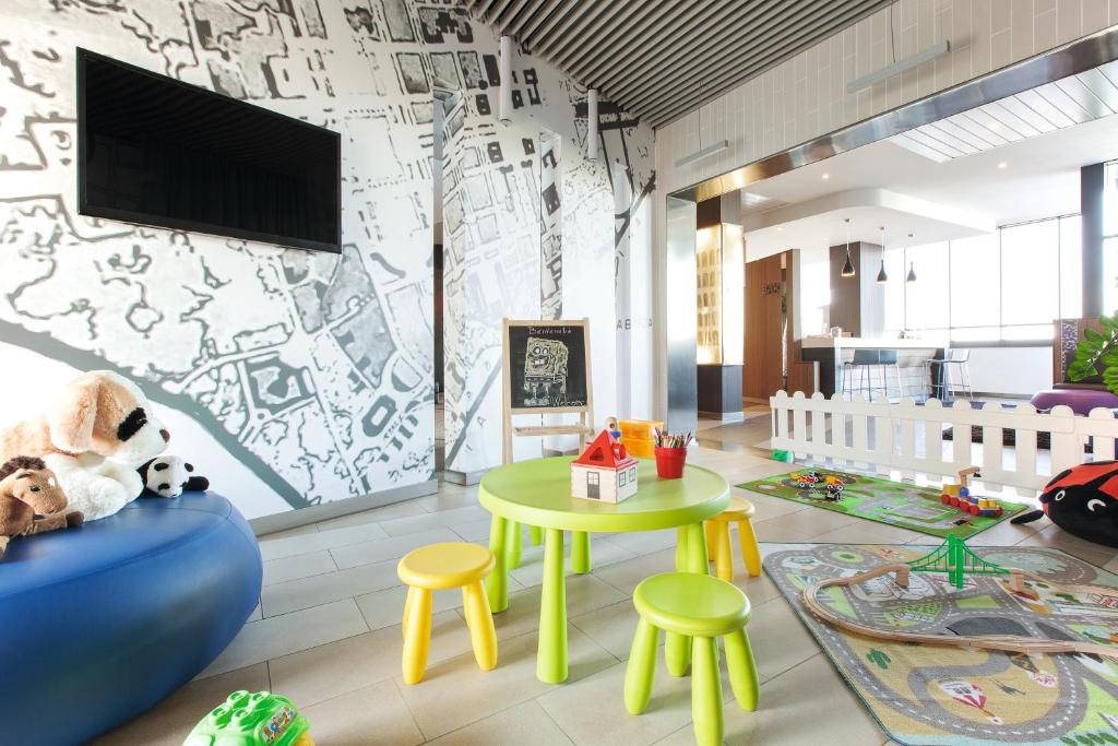 una camera con tavolo, sgabelli e TV di Ibis Styles Roma Eur a Roma