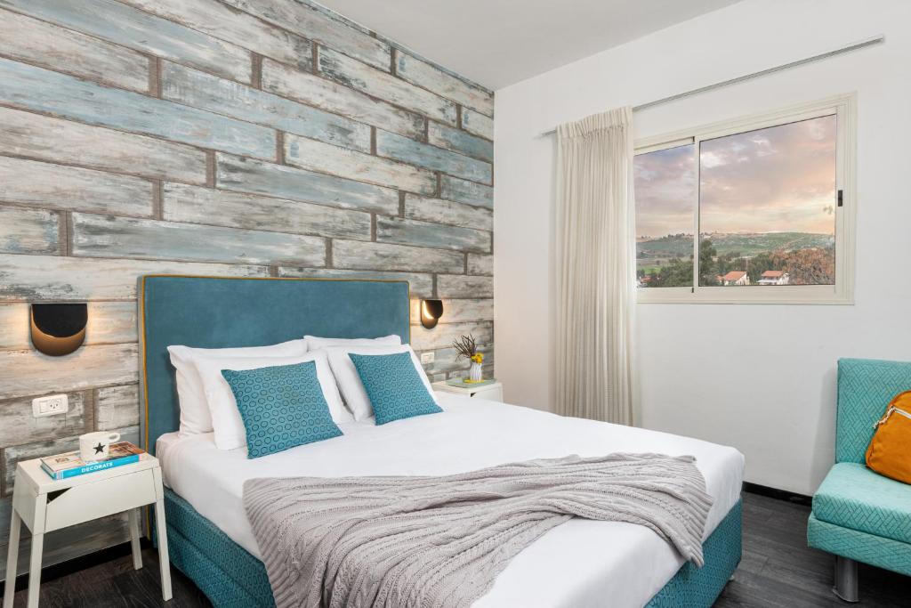 1 dormitorio con cama y pared de ladrillo en Metulla Travel Hotel en Metulla