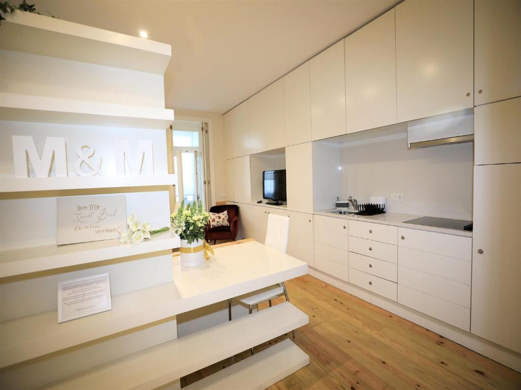 a kitchen with white cabinets and a table at M&M Space Apartments MM1 in Porto