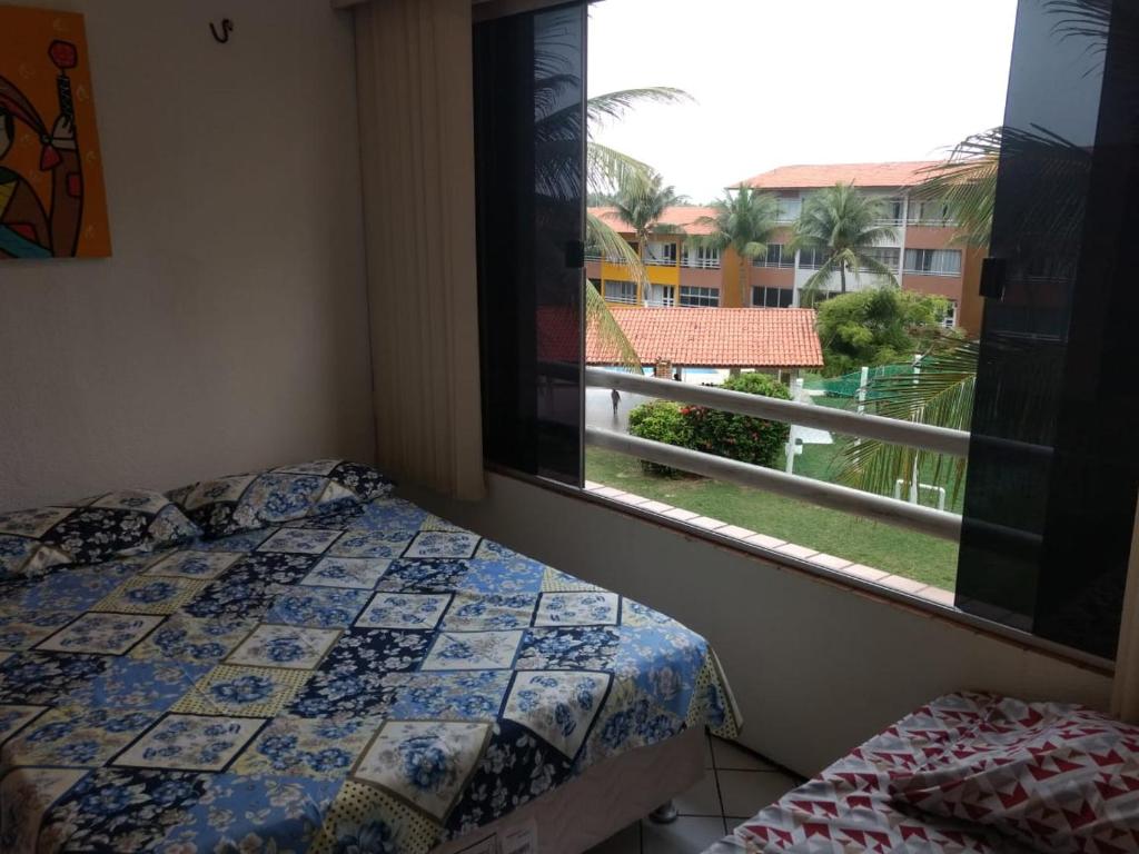 a bedroom with a bed and a window with a view at Ap por temporada com 2 quartos e uma suíte , excelente área de lazer, Praia do Futuro, condomínio Cartier-Fortaleza in Fortaleza