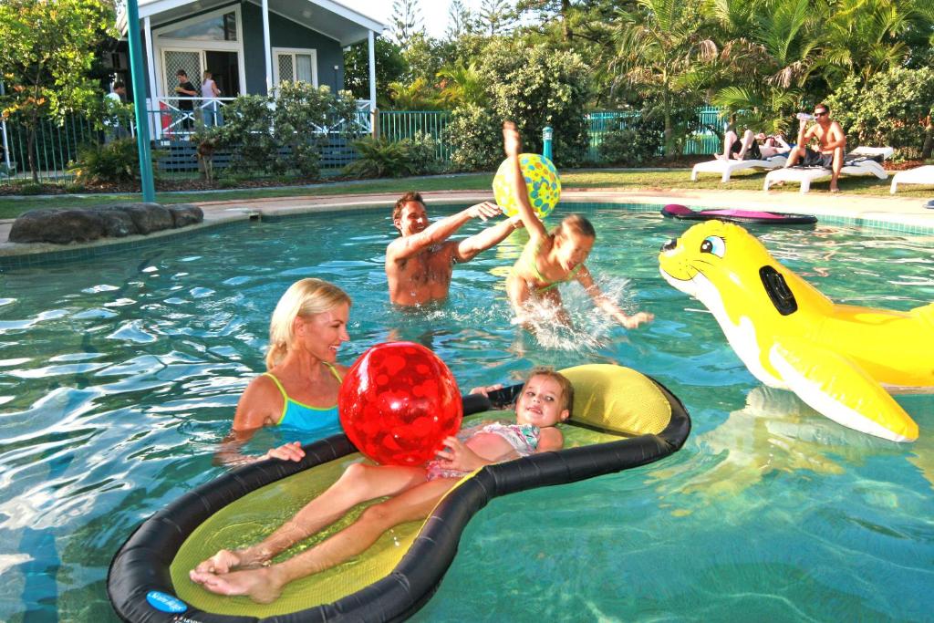 un groupe de personnes jouant dans une piscine dans l'établissement Main Beach Tourist Park, à Gold Coast