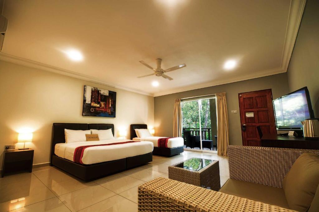 ティオマン島にあるティオマン ダイブ リゾートのベッドルーム(ベッド1台、ソファ、テレビ付)