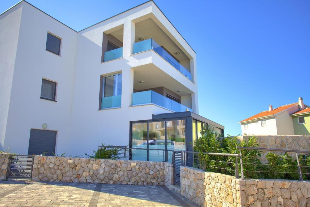 Casa blanca con pared de piedra en Apartment Crystal Aura, en Malinska