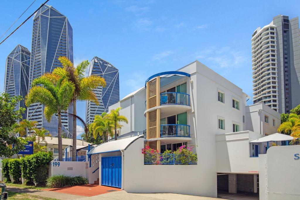 a white building with a blue door in front of a city at Surfers Beach Resort One in Gold Coast