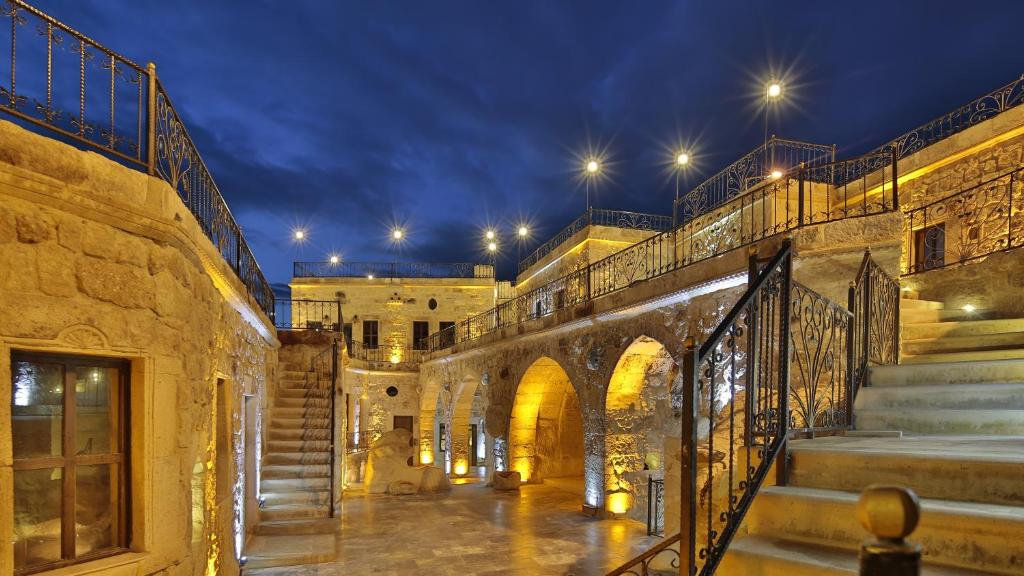 a courtyard of a building with stairs and lights at Golden Cave Suites in Urgup
