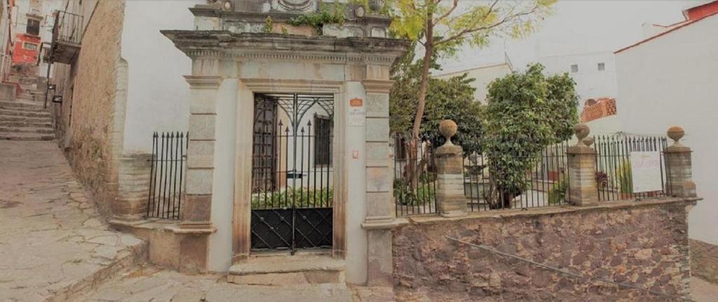 une porte menant à un bâtiment avec une clôture dans l'établissement Casa Lupita Hostel, à Guanajuato
