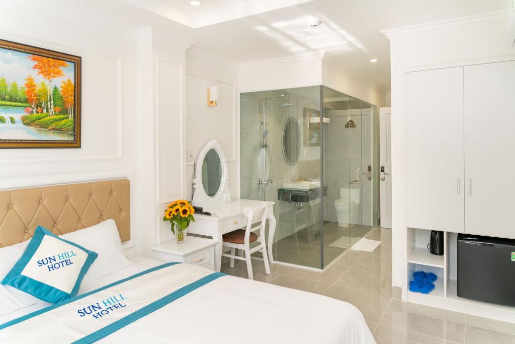 a white bedroom with a bed and a bathroom at Sun Hill Hotel in Vung Tau