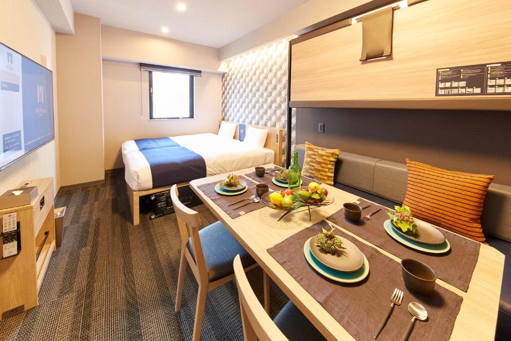 a hotel room with a table and a bed at MONday Apart Asakusabashi Akihabara in Tokyo