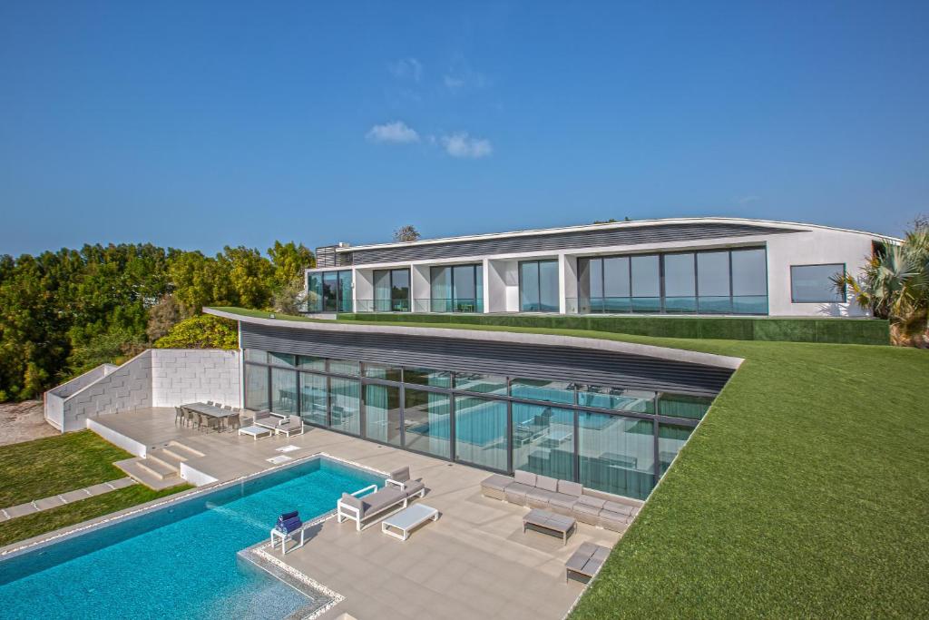 an aerial view of a house with a swimming pool at Paradise Nurai Villa - 6 Bedrooms in Abu Dhabi