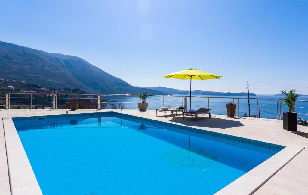 a swimming pool with an umbrella next to the water at Apartments Sandito in Mlini