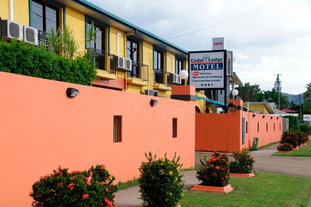 un bâtiment orange avec un panneau de motel devant lui dans l'établissement Cedar Lodge Motel, à Townsville