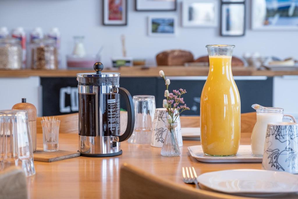 a wooden table with a jug of orange juice at Wildact Adventure AB in Storberg