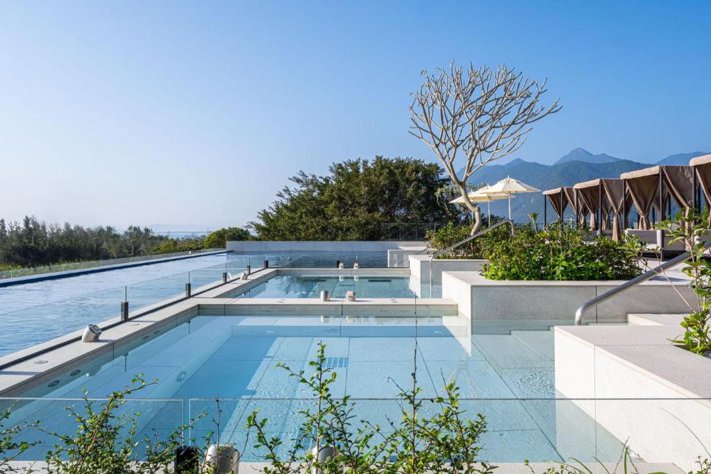 uma piscina num hotel com montanhas ao fundo em Lakeshore Hotel Hualien Taroko em Shunan