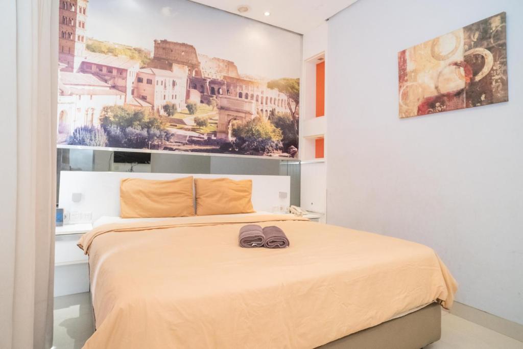 a bedroom with a bed with two slippers on it at RedDoorz at Tirta Mansion Paramount Gading in Jakarta