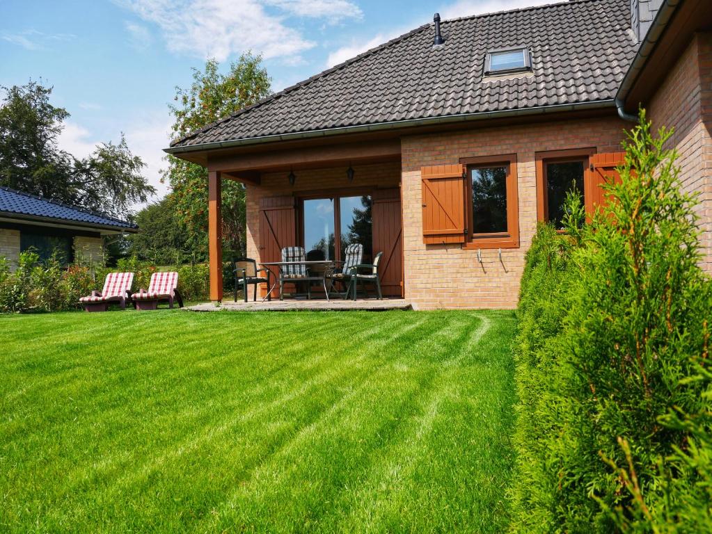 una casa con un cortile con erba verde di Landhaus am See von Robertville a Waimes