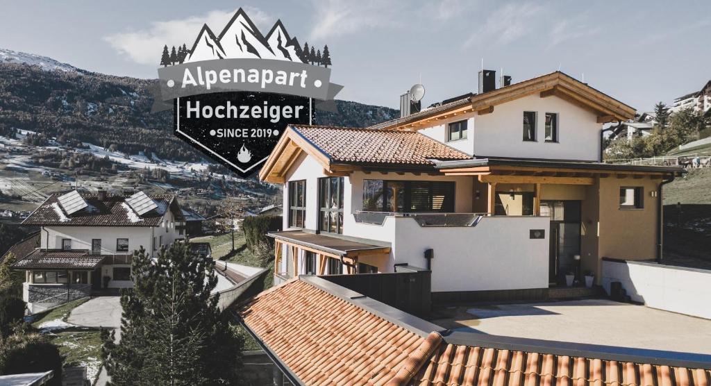 dom na wzgórzu z górami w tle w obiekcie Alpenapart Hochzeiger w mieście Jerzens