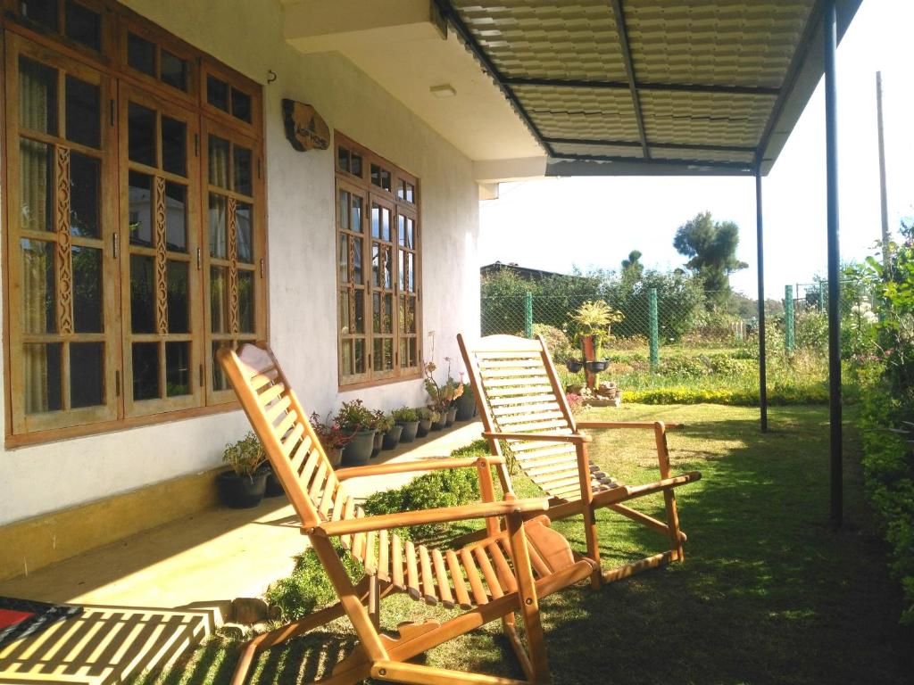 dos sillas sentadas en el porche de una casa en AGP home, en Nuwara Eliya