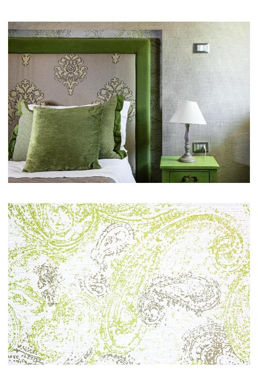 a bedroom with a green and white bed and a table at Hotel Salus in Pescara