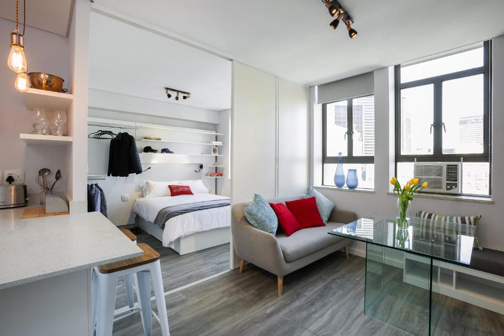 1 dormitorio con cama, sofá y mesa en 106 On Adderley Accommodation en Ciudad del Cabo