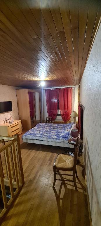 ein Schlafzimmer mit einem Bett, einem Tisch und einem Stuhl in der Unterkunft les jonquilles in Bussière-Galant