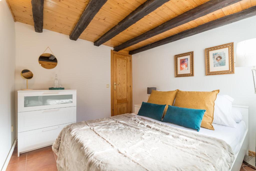 1 dormitorio con cama y techo de madera en MIT House Prado IV en Madrid, en Madrid