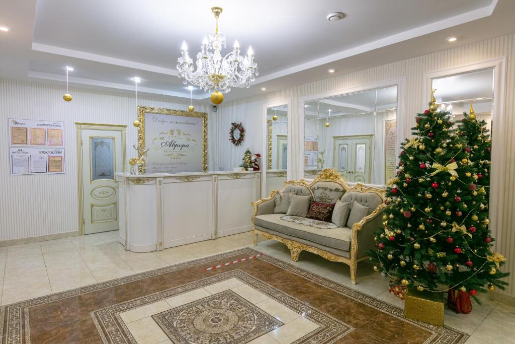 a living room with a christmas tree and a couch at АВРОРА гостиница in Arkhangelsk