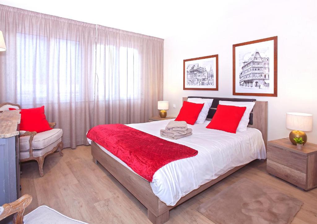 a bedroom with a large bed with red pillows at Centre - L'Impérial - Parking in Saverne