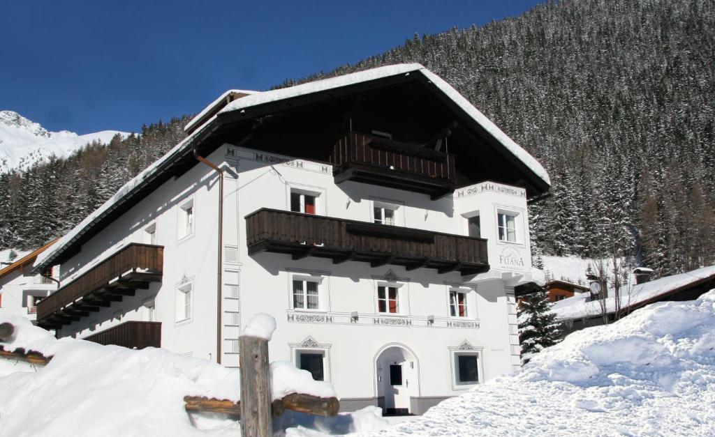 - un bâtiment blanc avec un balcon dans la neige dans l'établissement Appartements Fliana Mathon/Ischgl, à Ischgl