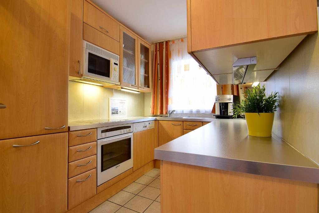 una cucina con armadi in legno e piano di lavoro di Linz Apartment Comfort-Size a Linz