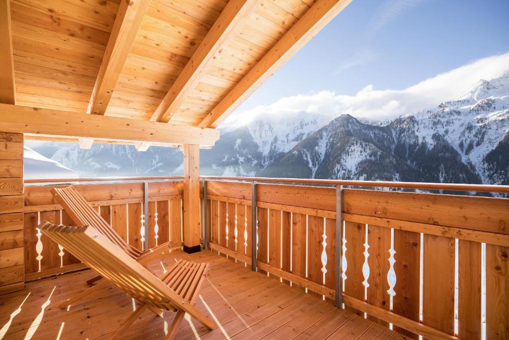 a room with a balcony with a view of mountains at Chalet Henne- Hochgruberhof in Selva dei Molini